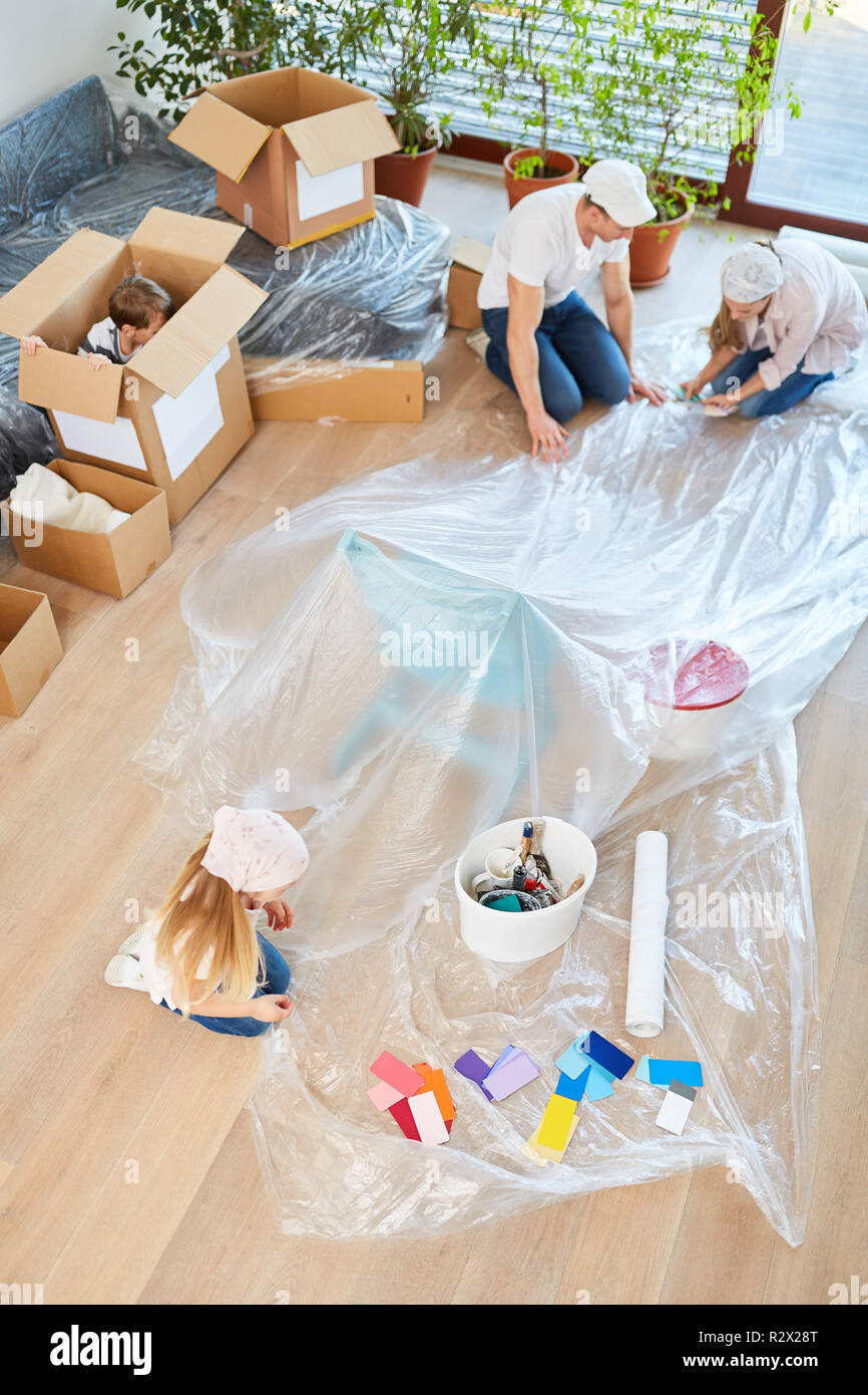 Familie und Kinder als Home Improvement bei der Renovierung und Malerei mit Plane Stockfoto
