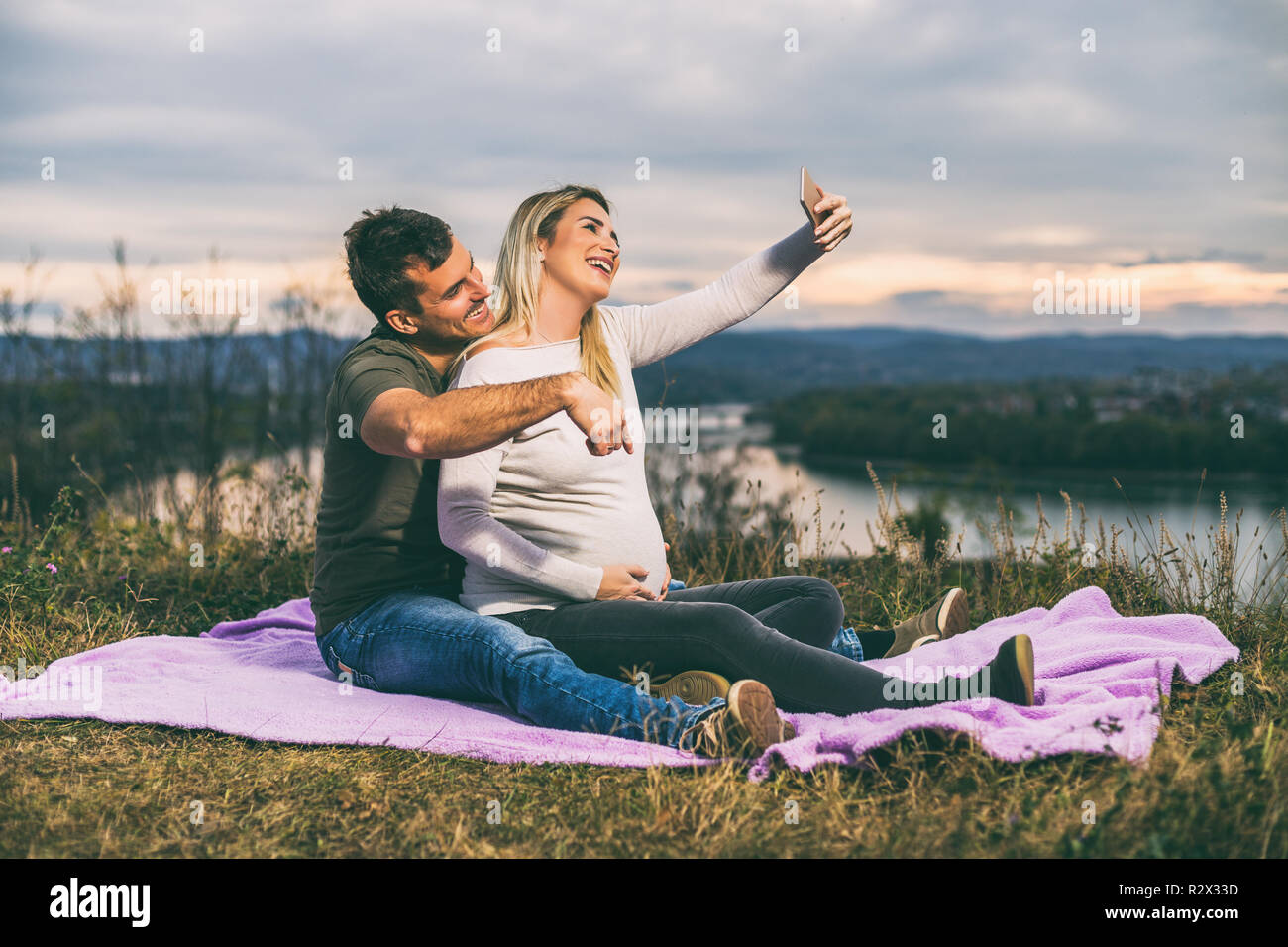 Gerne Mann und seine schwangere Frau, die selfie während Sie genießen die Zeit zusammen im Freien. Stockfoto