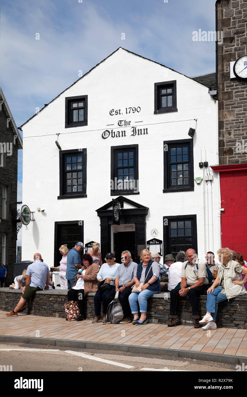 Die historische Oban Inn Erbaut im Jahre 1790, Oban, Argyll, Schottland mit Urlaub Touristen entspannen in den Vorplatz. Stockfoto