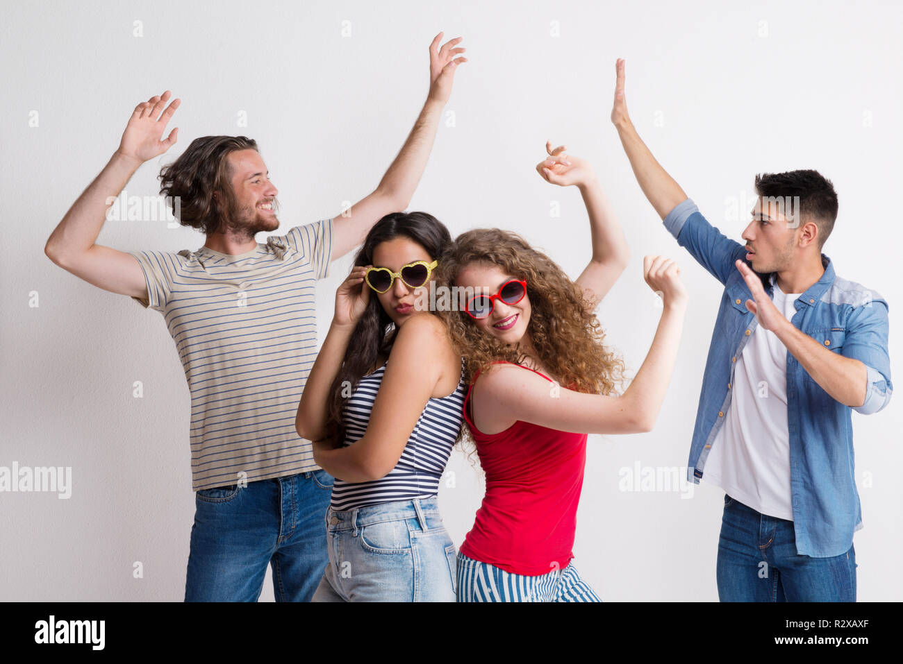 Portrait von fröhlichen jungen Freunde mit Sonnenbrille tanzen in einem Studio. Stockfoto