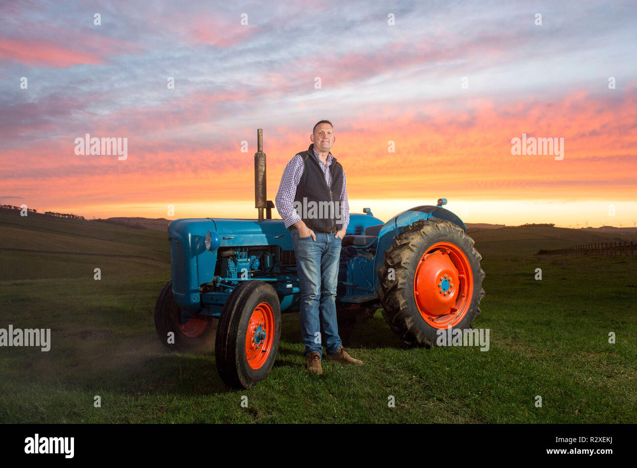 Ehemaliger schottischer Rugbyspieler Doddie Wehr dargestellt mit seinen fordson Dexta Schlepper auf seiner Farm in der Nähe von Galashiels. Stockfoto