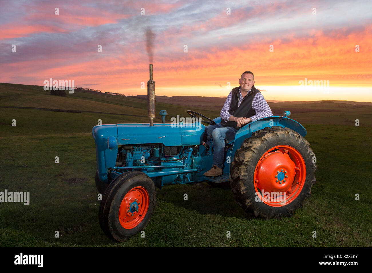 Ehemaliger schottischer Rugbyspieler Doddie Wehr dargestellt mit seinen fordson Dexta Schlepper auf seiner Farm in der Nähe von Galashiels. Stockfoto