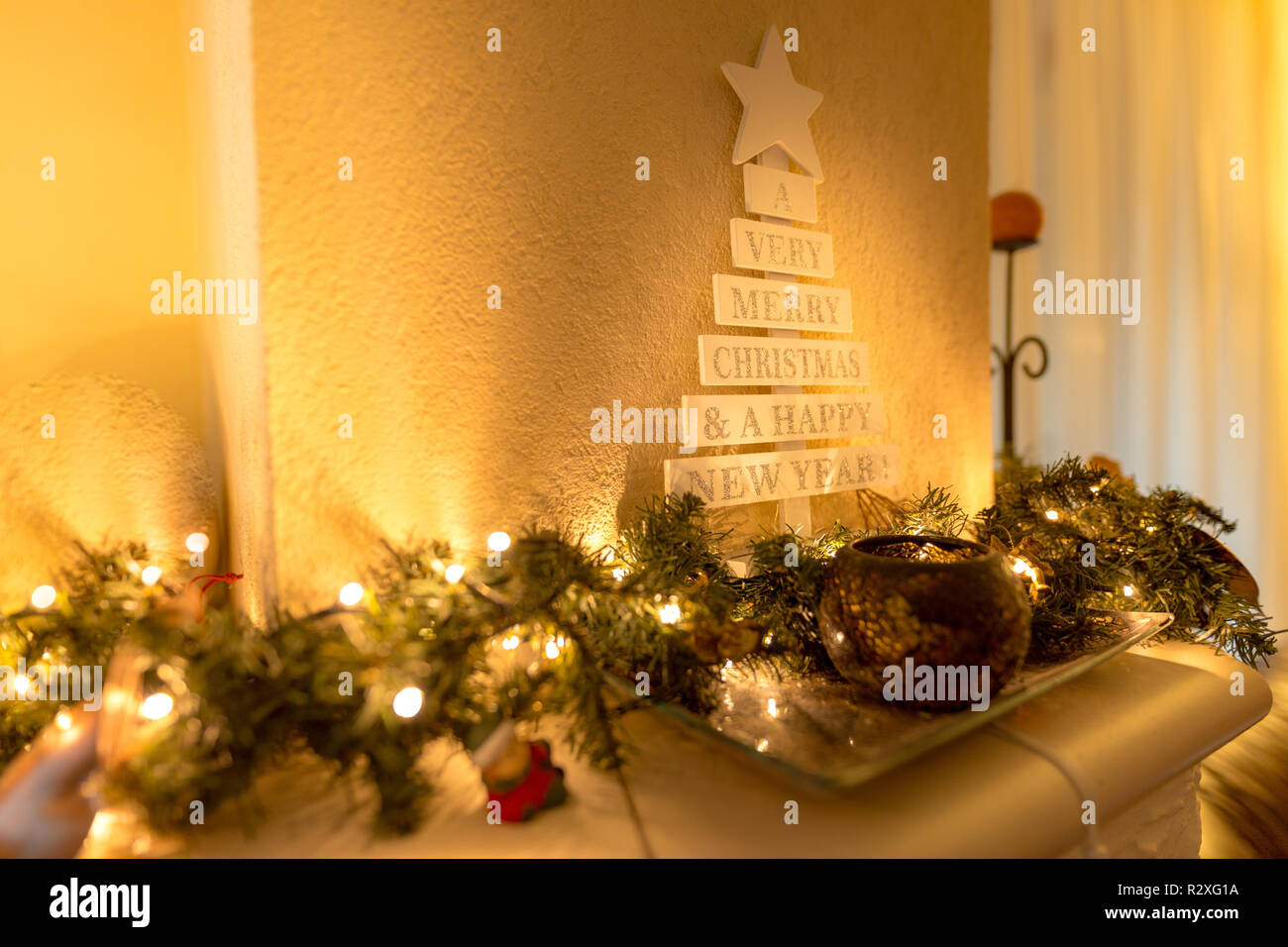 Weihnachtsbaum mit Vintage-Dekorationen in der Nähe von Kamin, LED-Lichter, goldene Dekoration für Weihnachten Stockfoto