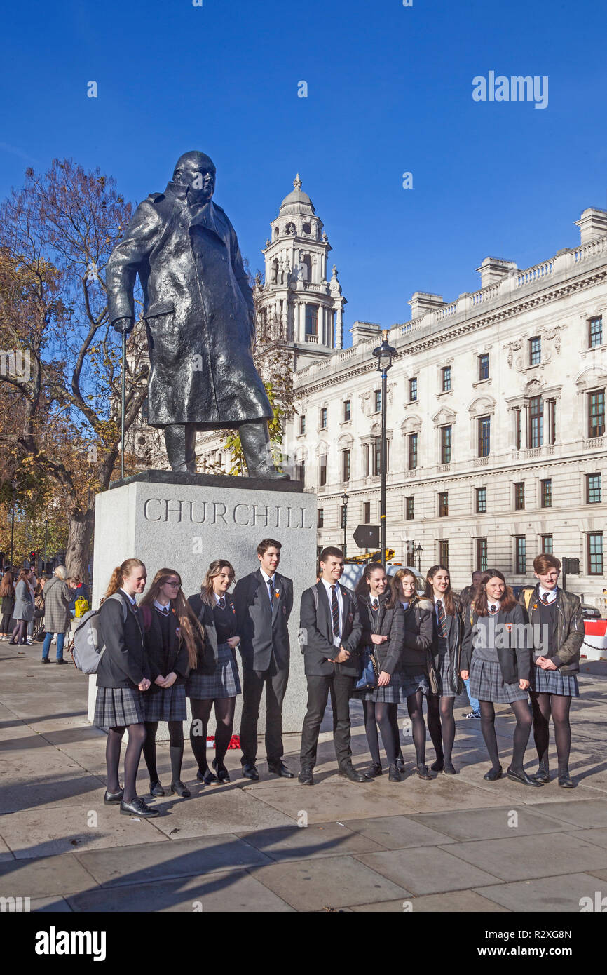 London, Westminster. Eine Schule Partei stellten sich für ein Gruppenfoto vor dem Churchill Statue in Parliament Square. Stockfoto