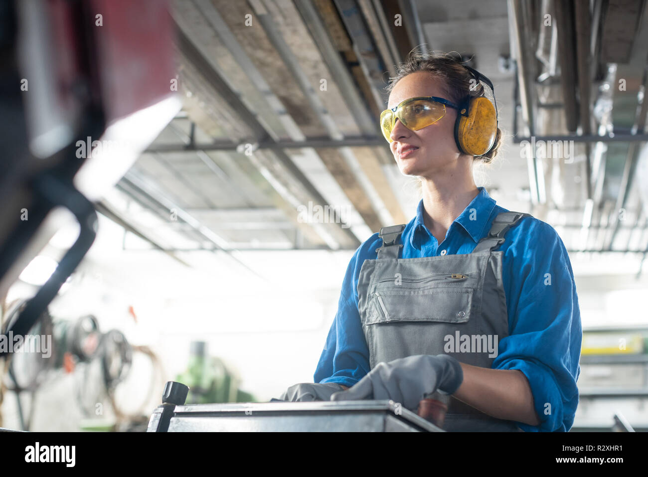 Arbeiterin der Betrieb einer Maschine Werkzeug in der metallwerkstatt oder nachträgliche Stockfoto