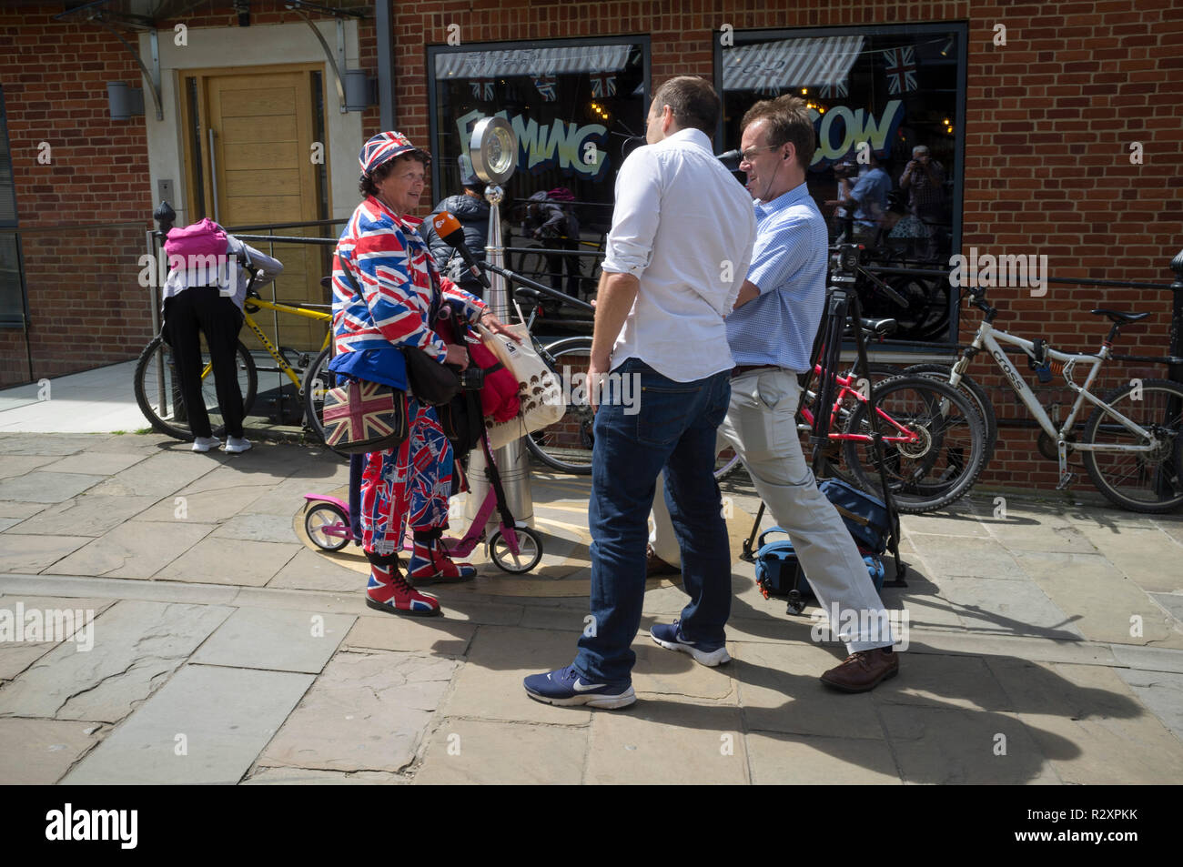 Ein Fernsehteam interviewt eine Frau in einem Union-Jack-Anzug am Tag vor der königlichen Hochzeit von Prinz Harry und Meghan Markle. Stockfoto