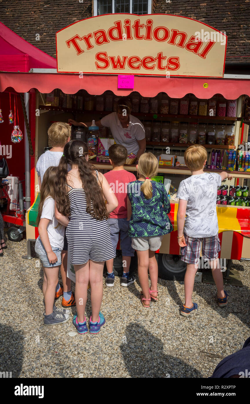Kinder Warteschlange an einem Stall für Traditionelle Bonbons an Yattendon Fete, Berkshire Stockfoto
