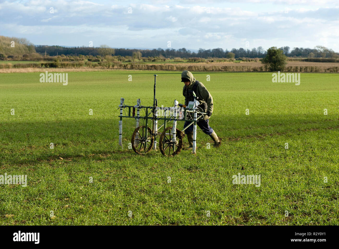 Geophysiker treibt ein Trolley mit Boden mapping Sensoren, wodurch eine geophysikalische Untersuchung des Untergrundes in einem Feld. Stockfoto