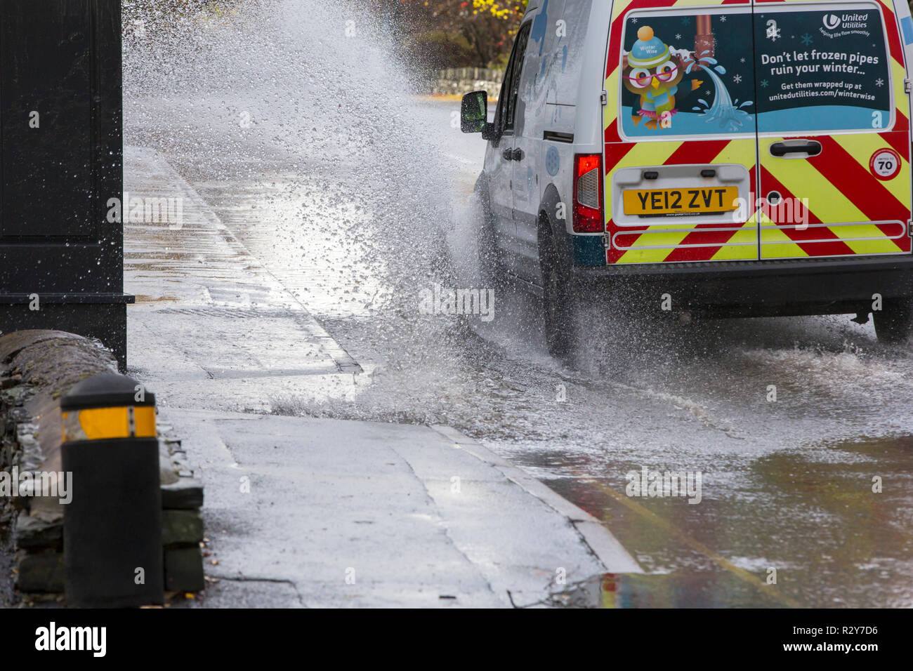 Autofahrer zu schnell gefahren durch grosse Pfützen einweichen Fußgänger und Unterkunft in Ambleside, Cumbria, Großbritannien. Stockfoto