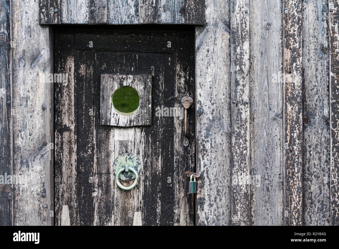 Eine hölzerne Tür aus dem Isländischen Torfhaus, Selfoss, Island. Die Tür und das Haus würde einmal abgedeckt wurden in Tar, die gerade sichtbar ist. Stockfoto