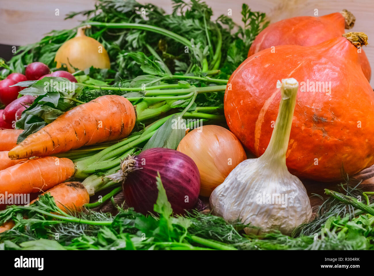 Die verschiedenen bunten Gemüse der Saison und Grüns liegen auf einem Tisch Stockfoto