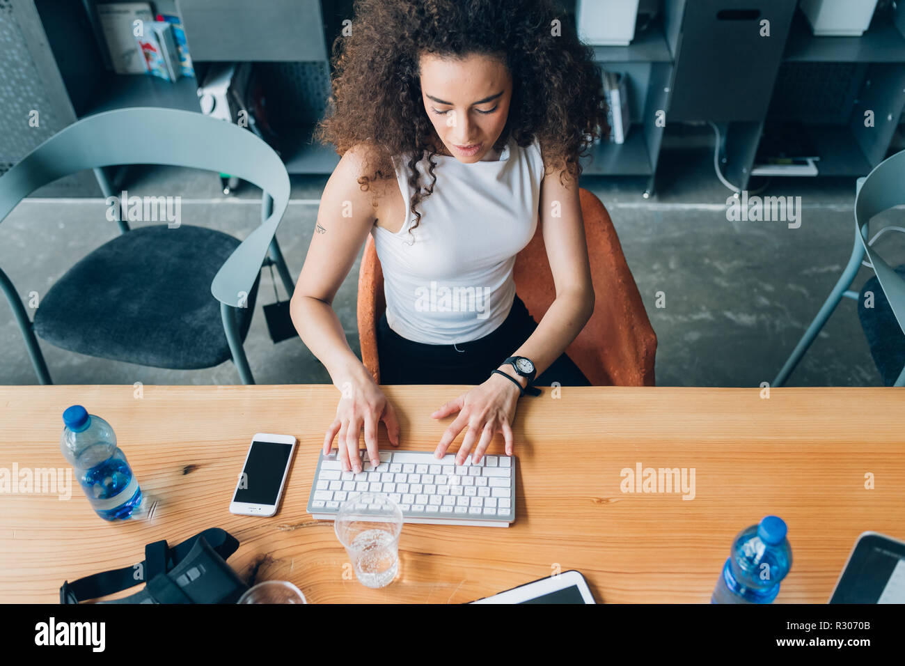 Junge kreative Frau innen sitzen Desking mit Laptop - Telearbeit, startupper, smart Arbeitnehmer Konzept Stockfoto