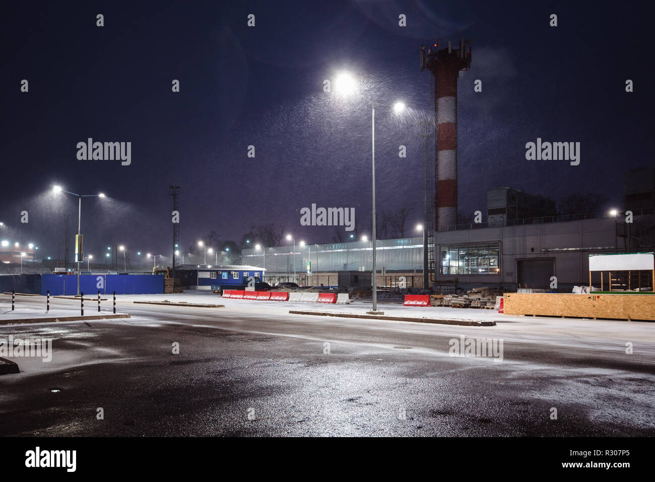 Industriegebiet am Rande der Stadt in der Nacht. Straße leuchten der Schnee von oben Stockfoto