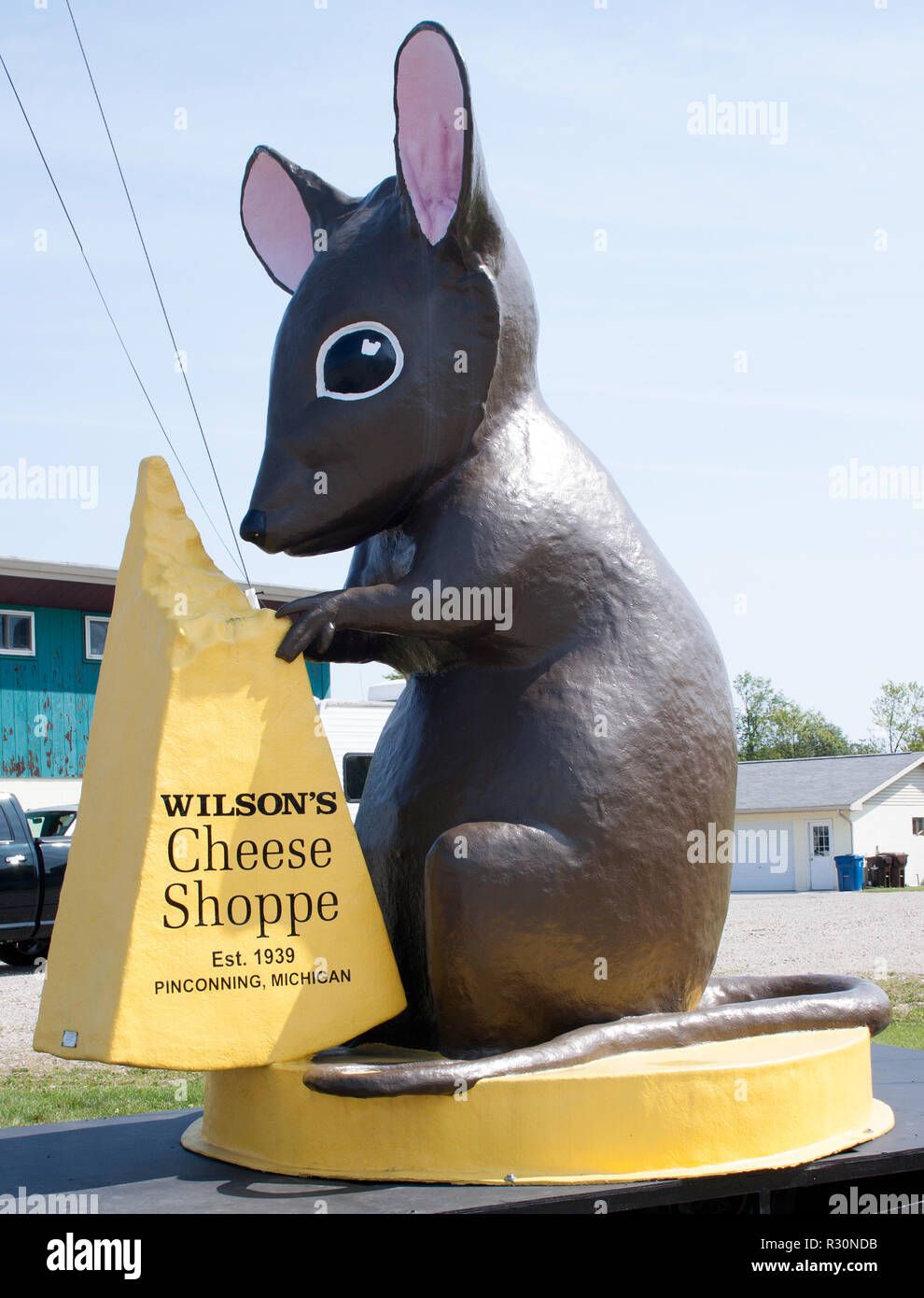 Eine riesige Mausstatue begrüßt Besucher vor einem Käsegeschäft in Pinconning, Michigan – Cheddar-Charme und Spaß am Straßenrand. Stockfoto