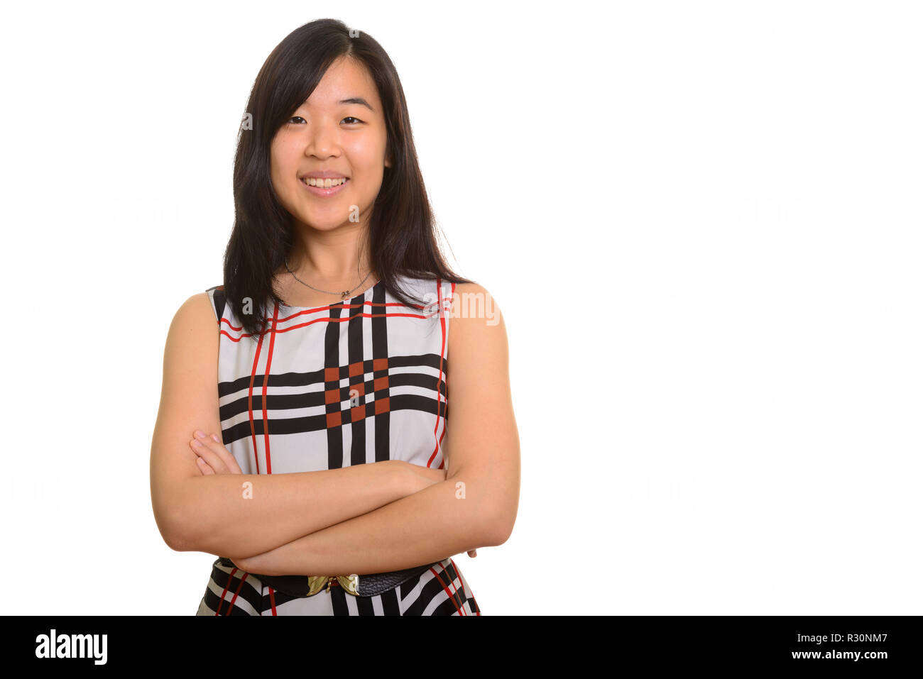 Junge gerne asiatische Geschäftsfrau lächelnd mit gekreuzten Armen Stockfoto