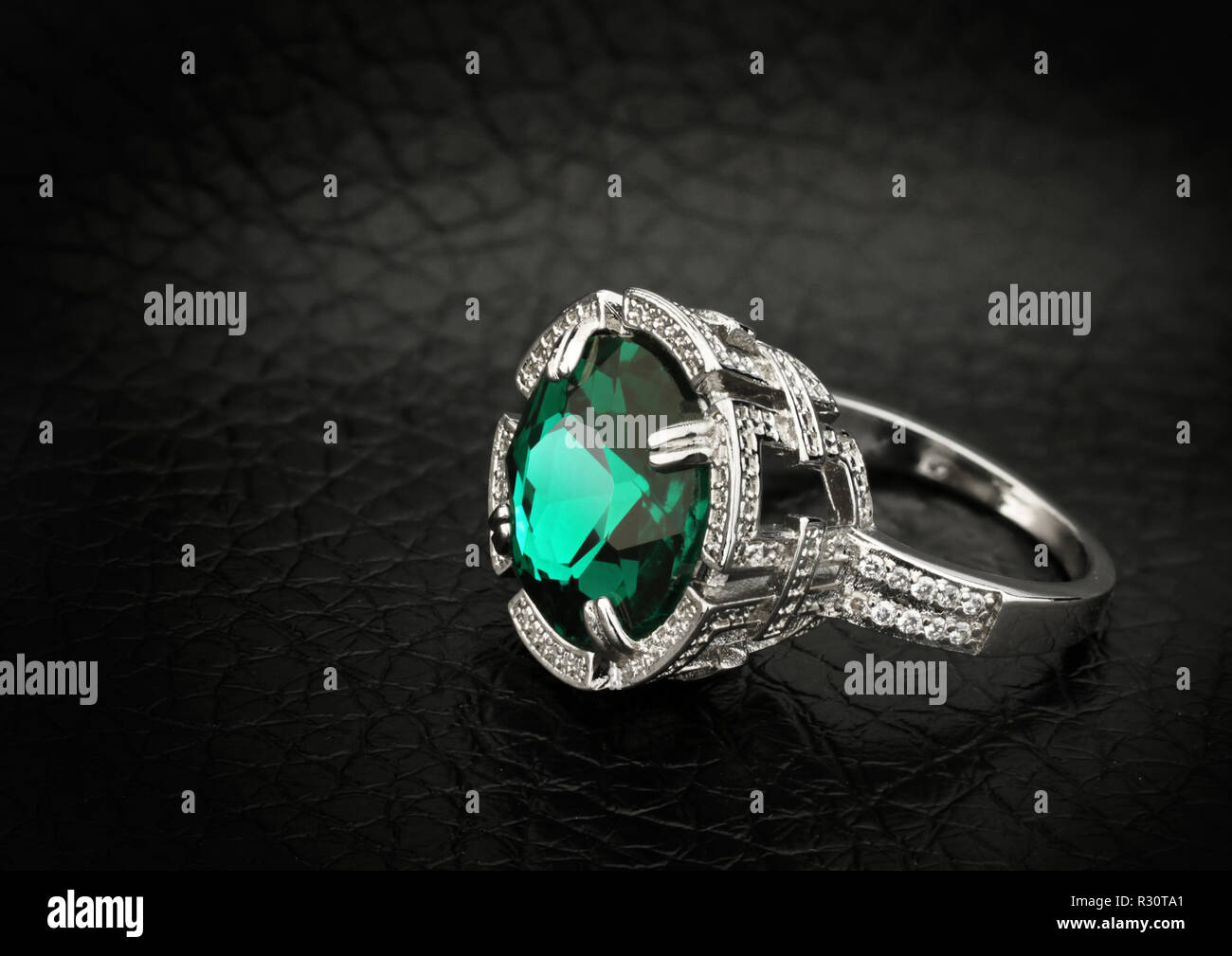 Schmuck Ring mit großen grünen Edelstein auf schwarzem Leder Hintergrund Kopie Raum Stockfoto