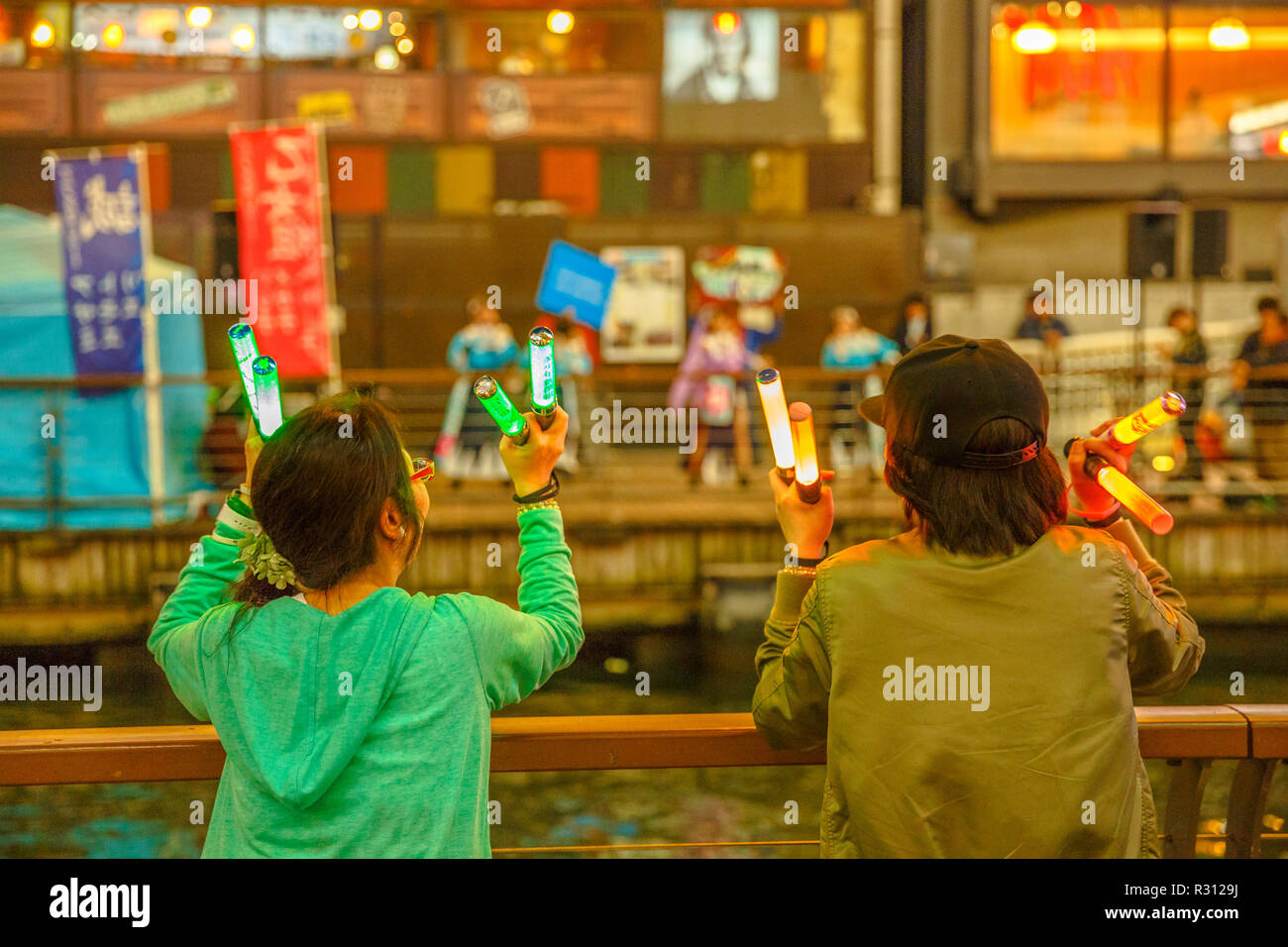 Singen japanisches Idol Mädchen im Konzert mit den Fans tanzen. Dotonbori Canal an Blaue Stunde in Namba Viertel, einem beliebten Einkaufs- und Unterhaltungsviertel von Osaka in Japan. Stockfoto