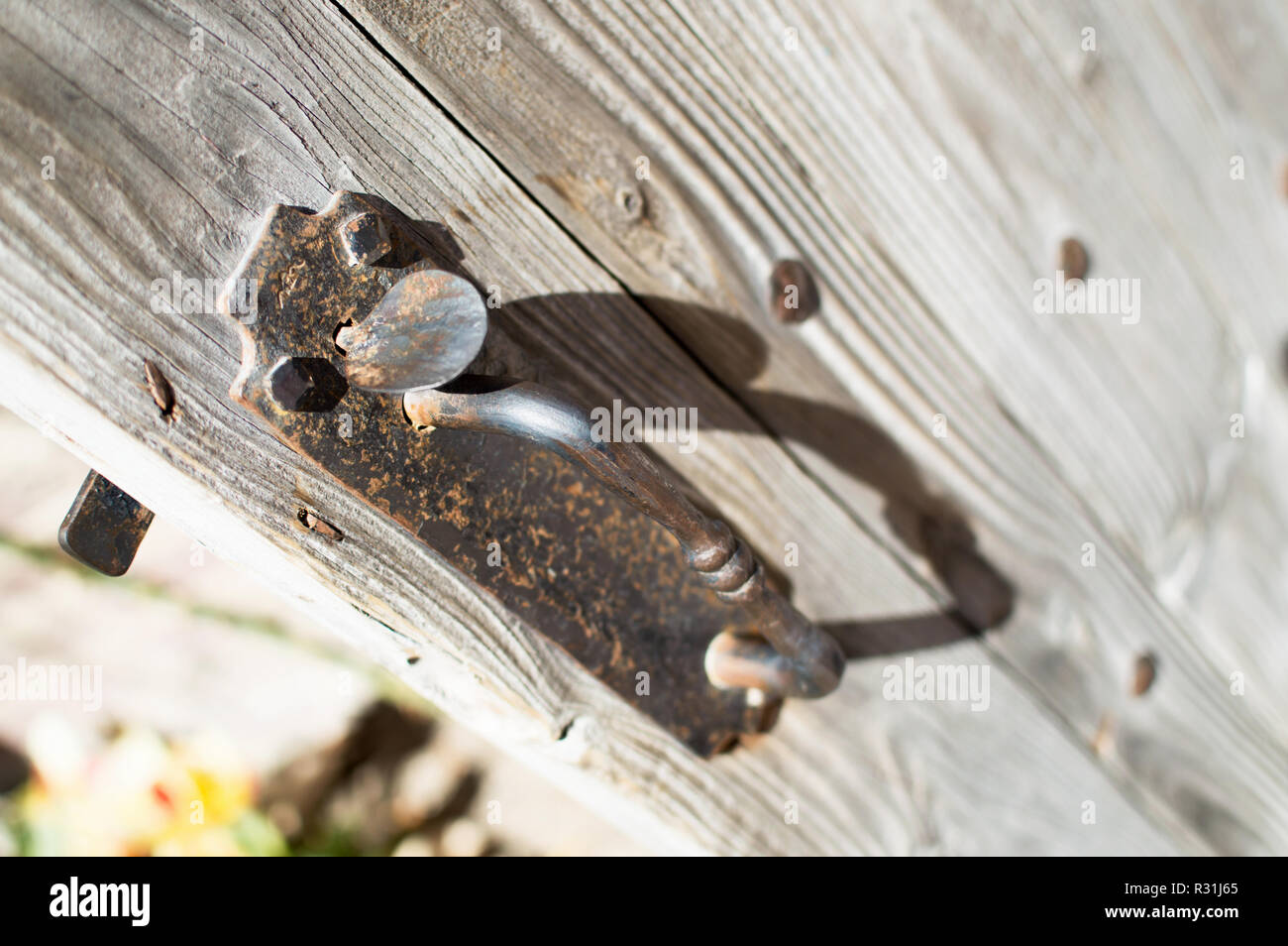 Ein rostiger altmodische Türgriff auf einer rauhen Holz Tür. Stockfoto