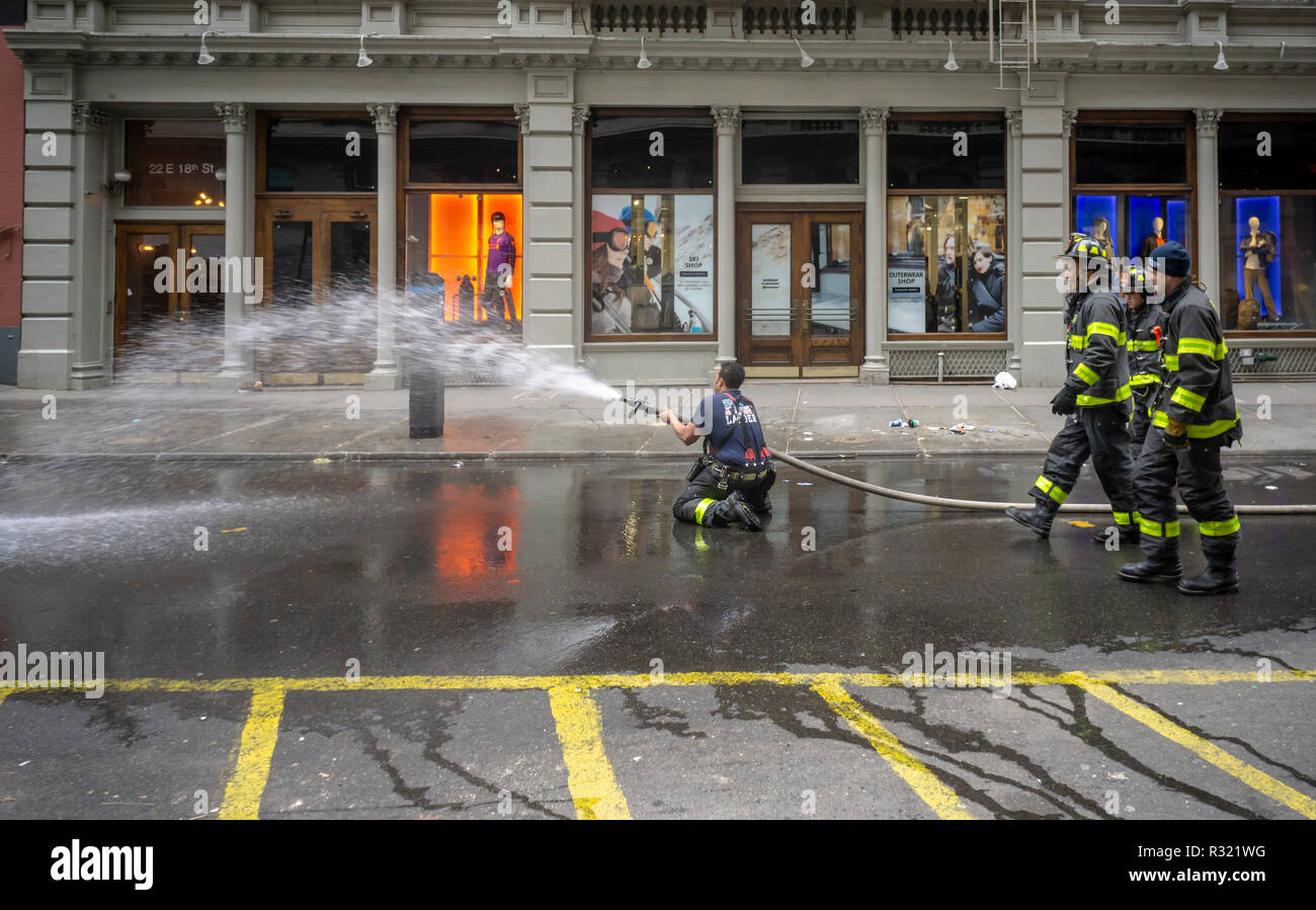 Ein Feuerwehrmann zeigt die richtige Verwendung einer Schlauch außerhalb des firehouse in der Nähe des Union Square in New York am Samstag, 17. November 2018. (Â© Richard B. Levine) Stockfoto