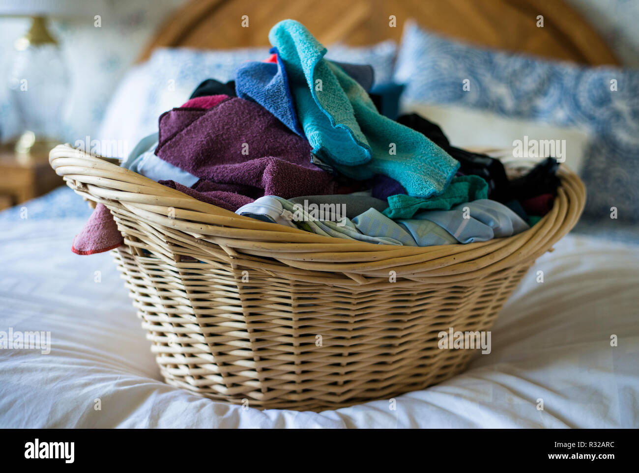 Wäschekorb von Kleidung auf einem Bett. Stockfoto