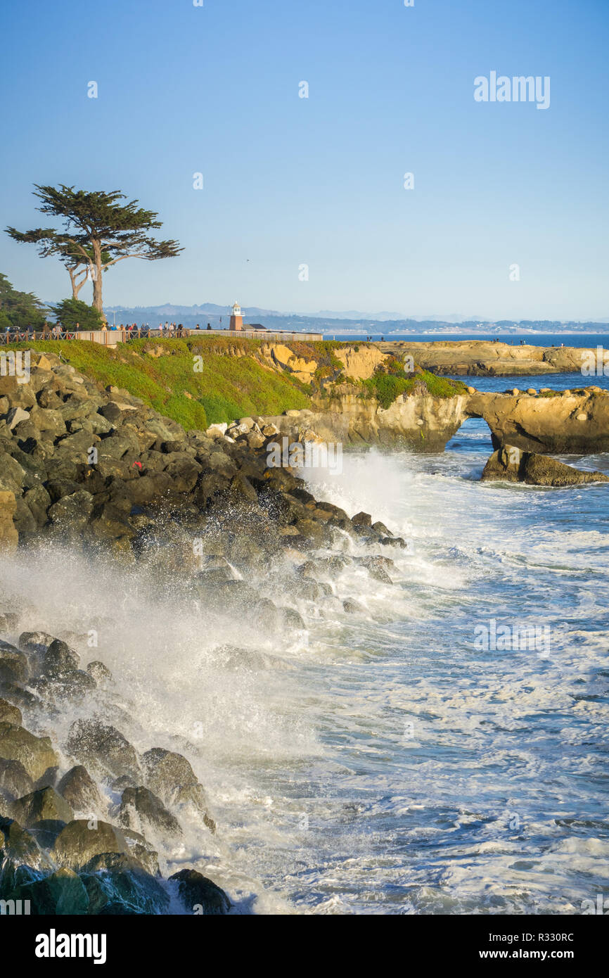 Wellen, die auf der felsigen Küste des Pazifiks; Santa Cruz Surfing Museum im Hintergrund; Kalifornien Stockfoto