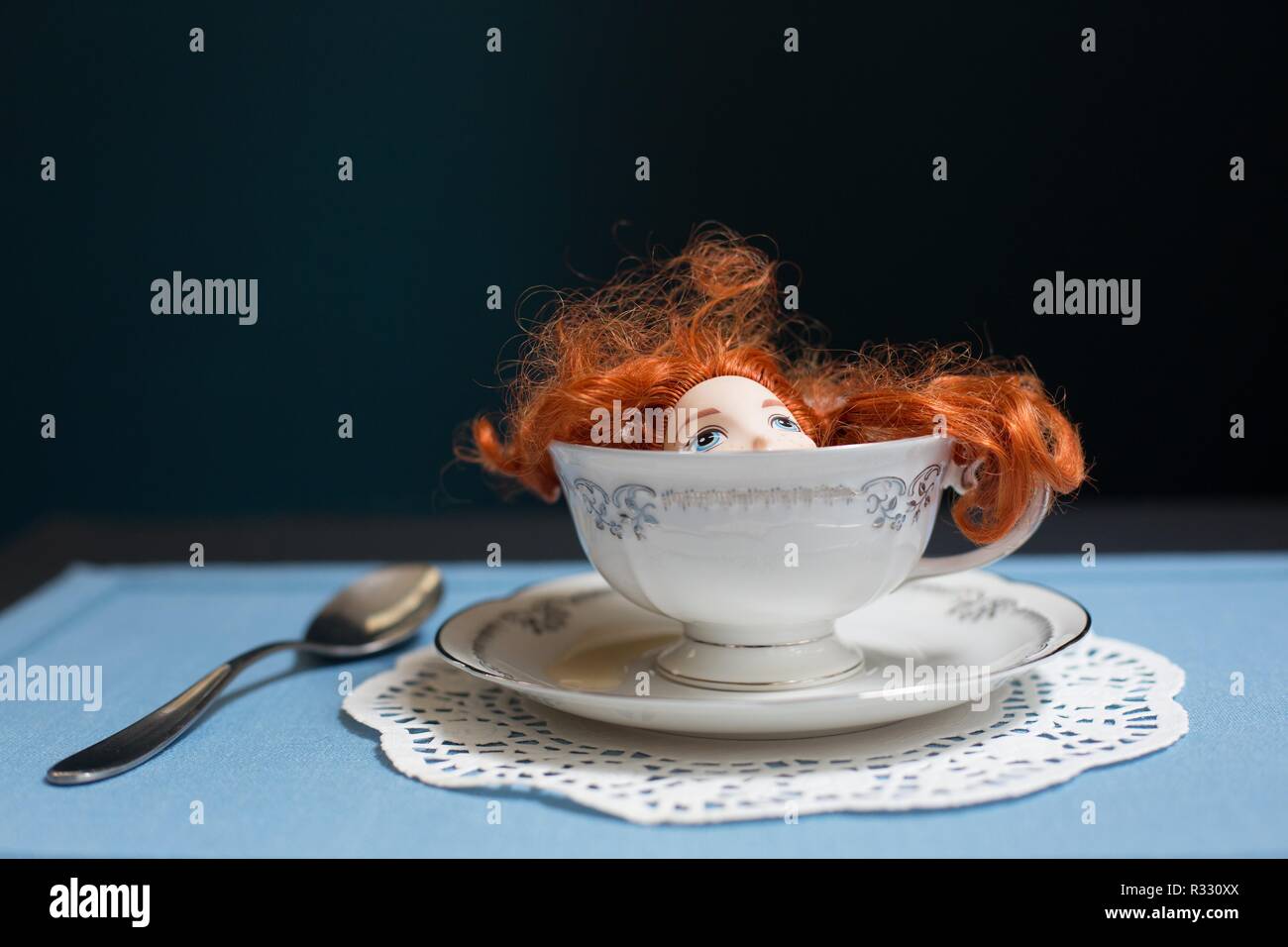 Surreale Bild der Rothaarige Puppe in einer Tasse Tee. Stockfoto