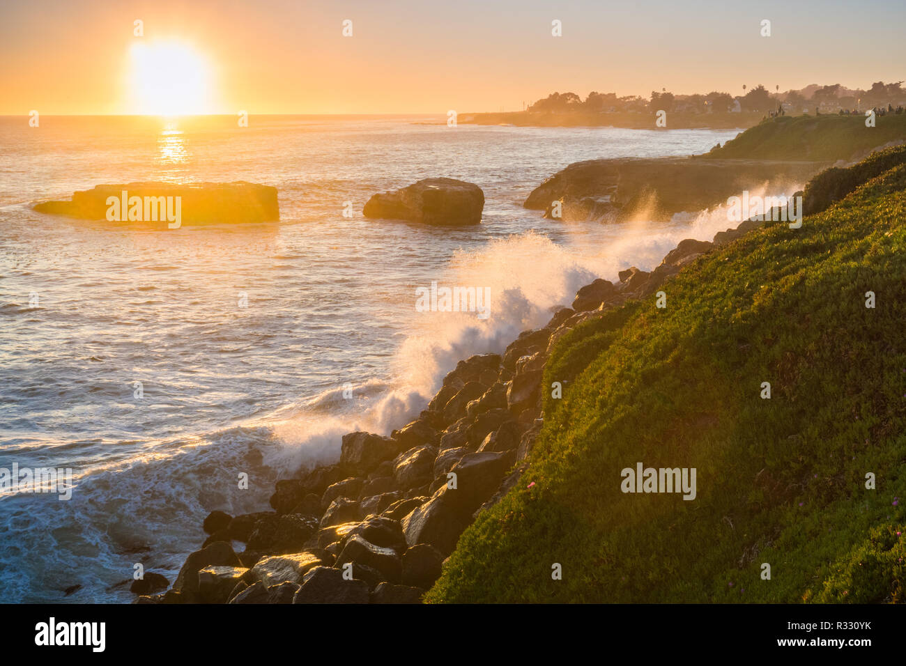 Die Wellen brechen an der felsigen Küste bei Sonnenuntergang, Santa Cruz, Kalifornien Stockfoto
