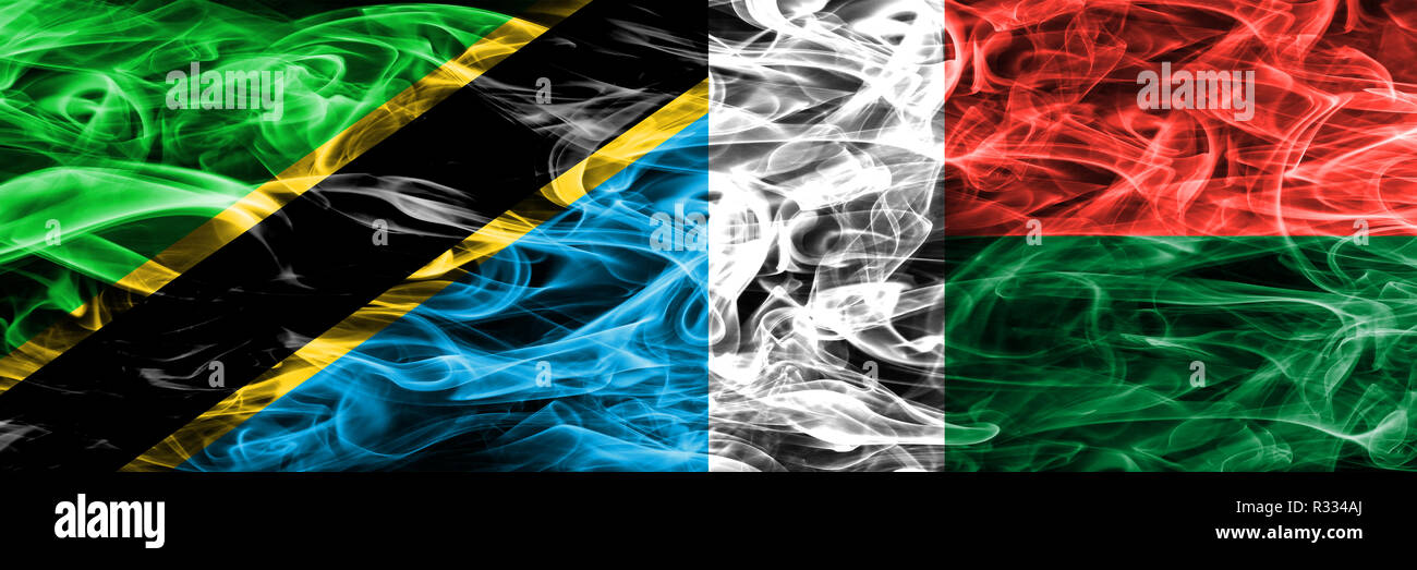 Tansania vs Madagaskar, madagassischen Rauch Flaggen nebeneinander gestellt. Dicke farbige seidig Rauch Fahnen von Tansania und Madagaskar, madagassischen Stockfoto