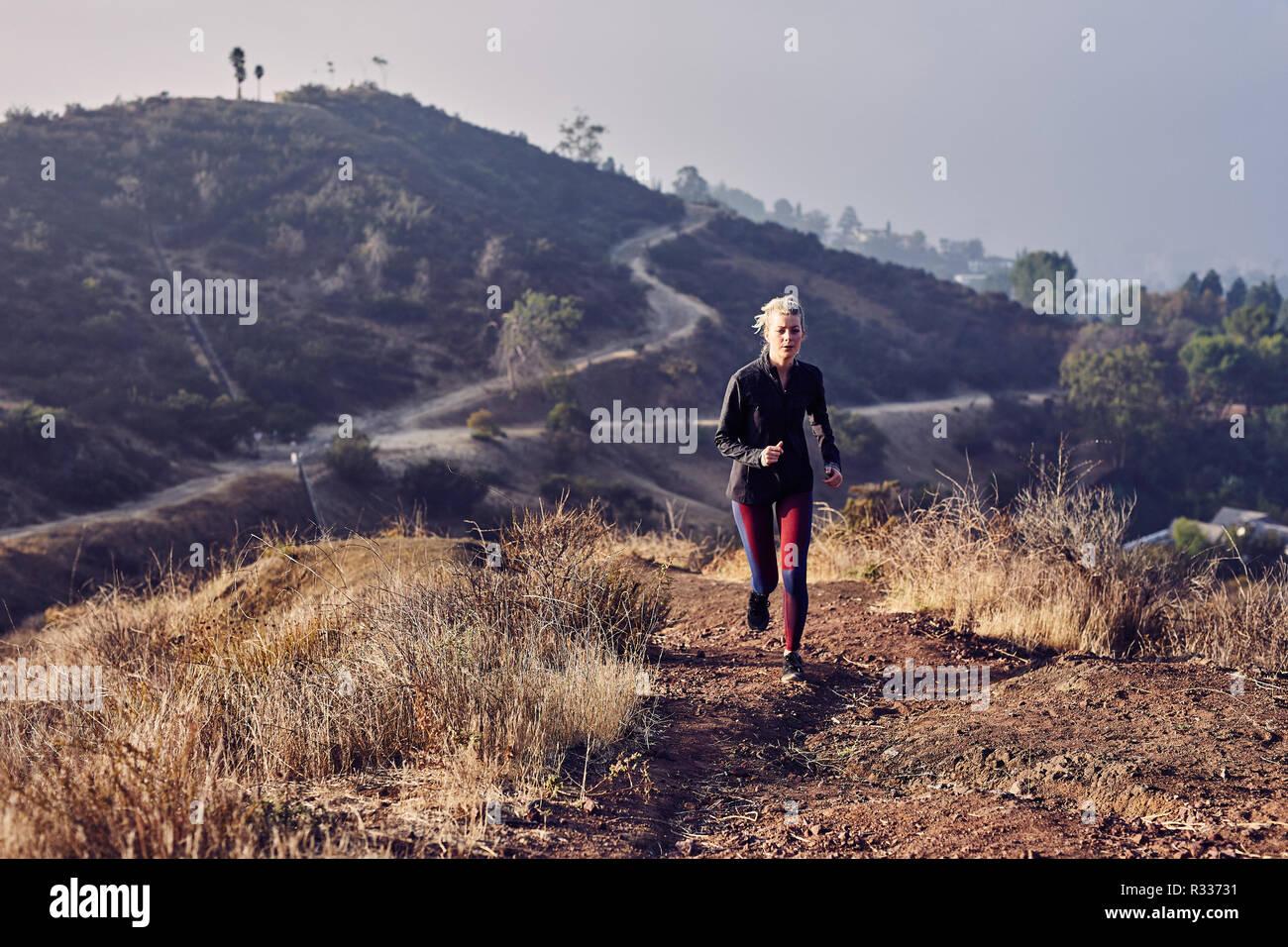 Schönen Kaukasischen weiß Frau läuft auf einem Trail in der Morgensonne Stockfoto