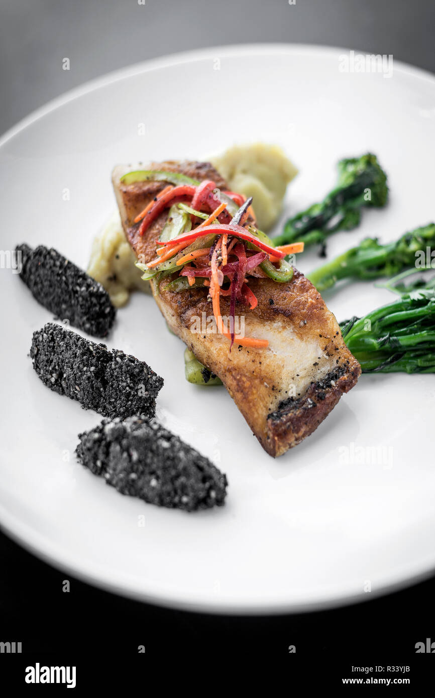 Red Snapper Fischfilet mit Gemüse und schwarzen Reis mit schwarzem Sesam asiatische moderne Fusion Gericht in Melbourne, Australien, Restaurant Stockfoto