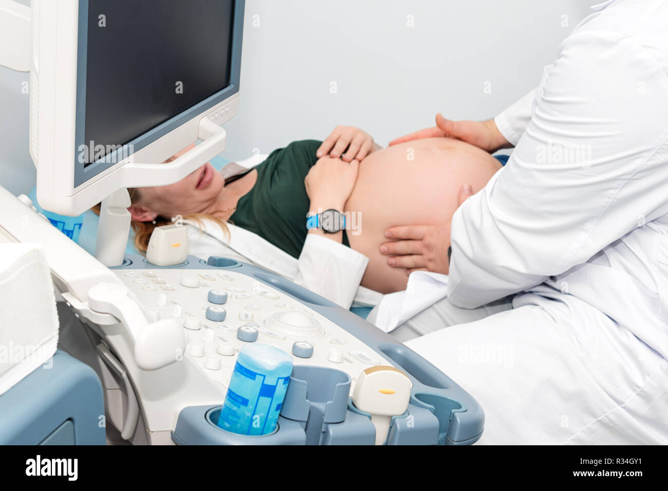 Arzt Durchführung Ultraschall für schwangere Frau in der Klinik. Erwartungen des Kindes und der Diagnose mit Ultraschall Stockfoto