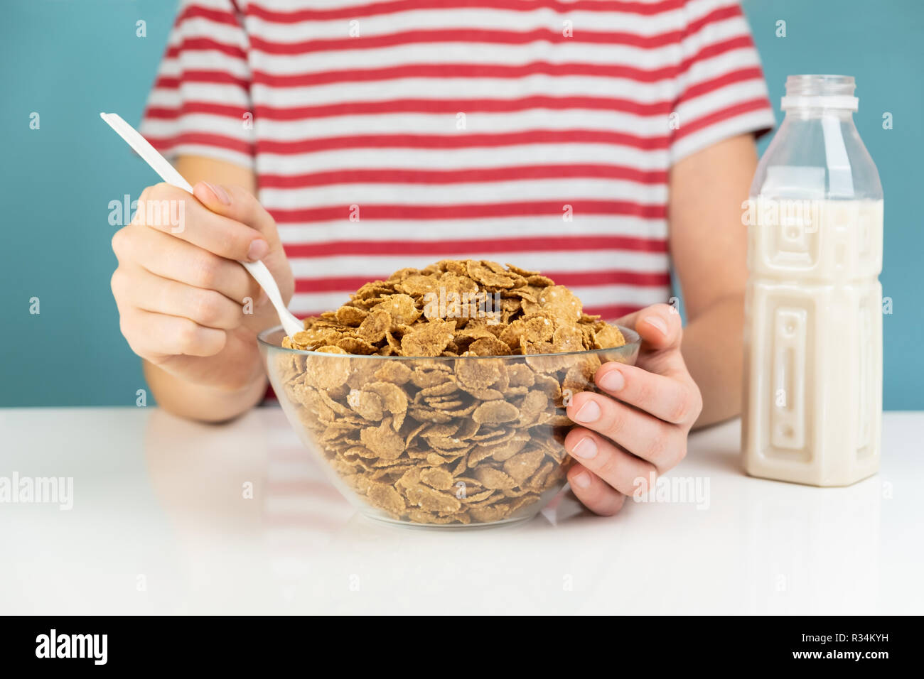Gesundes Frühstück mit Vollkorn Getreide und Milch Konzept. Illustrative minimalistisch Bild von vegetarisches Essen auf den Tisch und hungrige Person Stockfoto