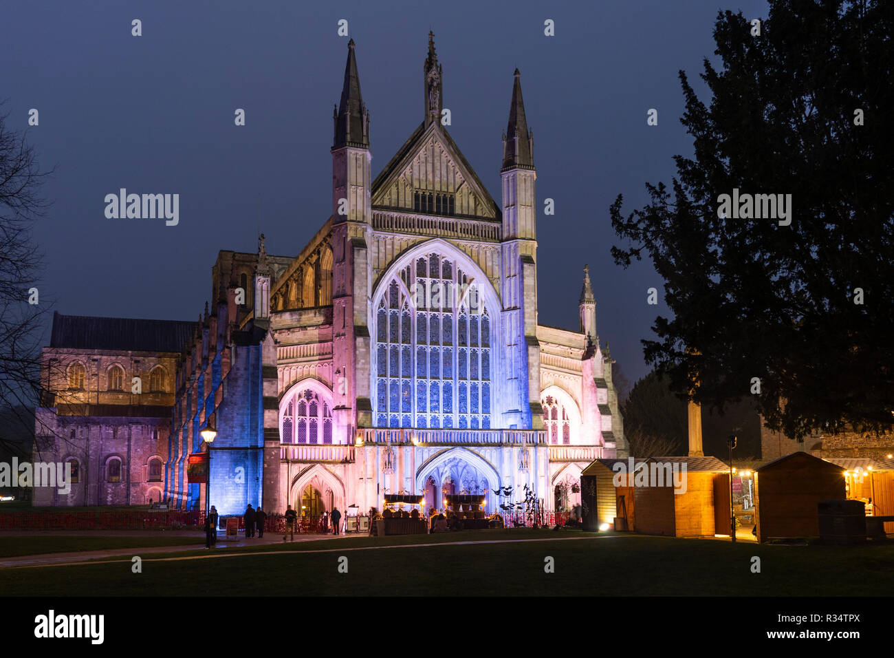 Die gotische Kathedrale von Winchester bei Nacht beleuchtet und Winchester Weihnachtsmarkt - beliebte Touristenattraktionen in der ehemaligen Hauptstadt von England Stockfoto