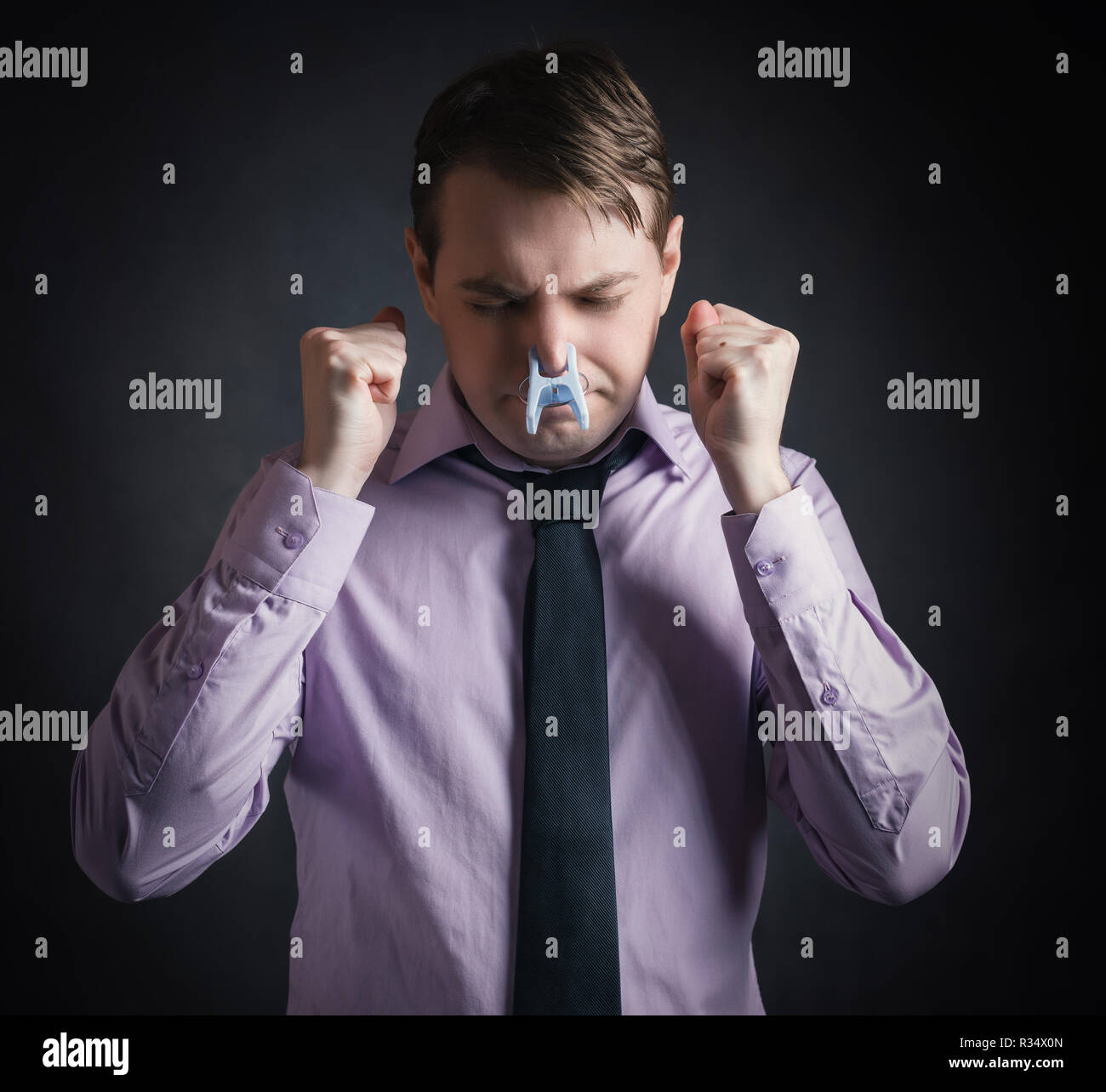 Portrait der junge Geschäftsmann Mann mit Wäscheklammer auf der Nase - schlechter Geruch Konzept Fotografie. Stockfoto