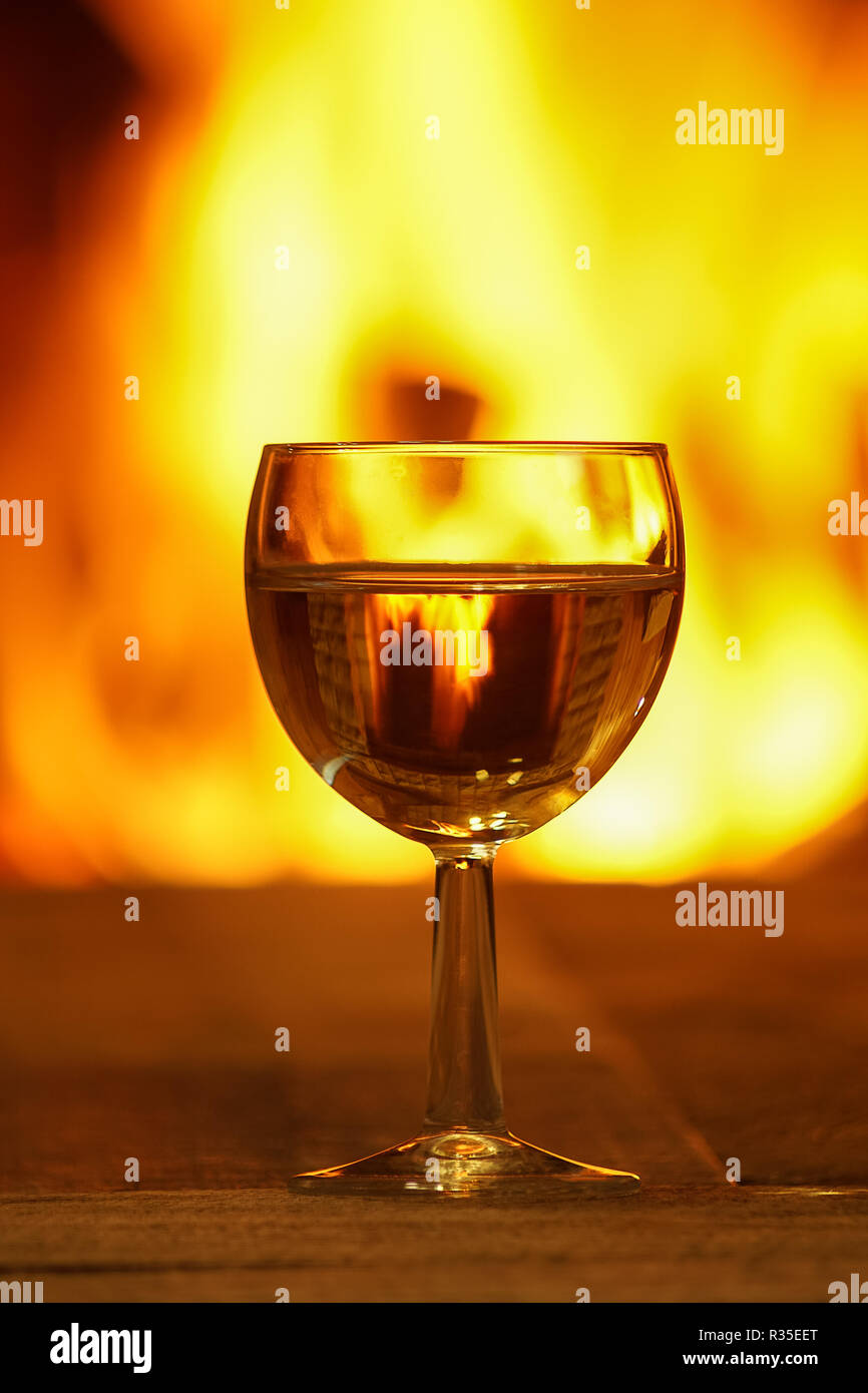 Glas Weißwein gegen gemütlichen Kamin Hintergrund, winter Urlaub, Winter Urlaub, Landhaus, horizontal. Stockfoto