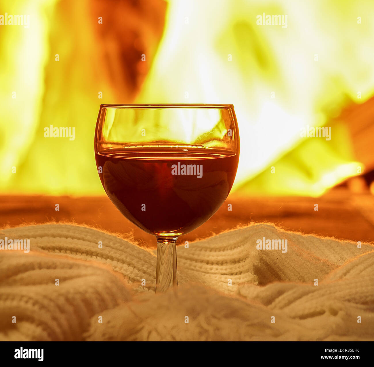 Glas Rotwein ; und Wolle; die Dinge gegen gemütlichen Kamin Hintergrund; Winterurlaub; Horizontal; closeup; selektive konzentrieren. Stockfoto