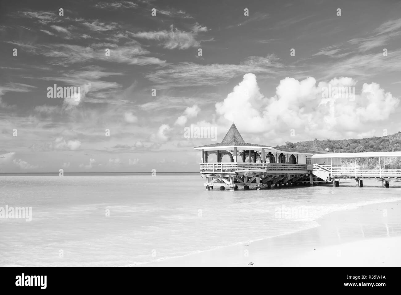 Kommen Sie und bleiben. Meer türkis Ruhe und Bungalow Terrasse auf dem Wasser. Ferienhäuser Meer Sand Strand gemütliche tropischen Haus bungalow St Johns Antigua. Idyllischer sonniger Tag am Meer blauer Himmel. Paradise Sea Resort. Stockfoto