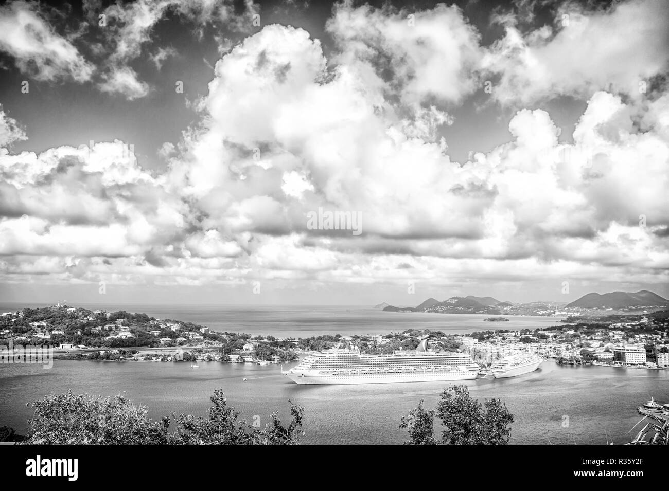 Castries, St. Lucia - 26. November 2015: Kreuzfahrtschiffe im Hafen an bewölkten Himmel. Stadt am blauen Meer mit Berglandschaft. Sommerurlaub auf der Insel. Luxus Reisen auf dem Boot, Wasser transportieren. Stockfoto