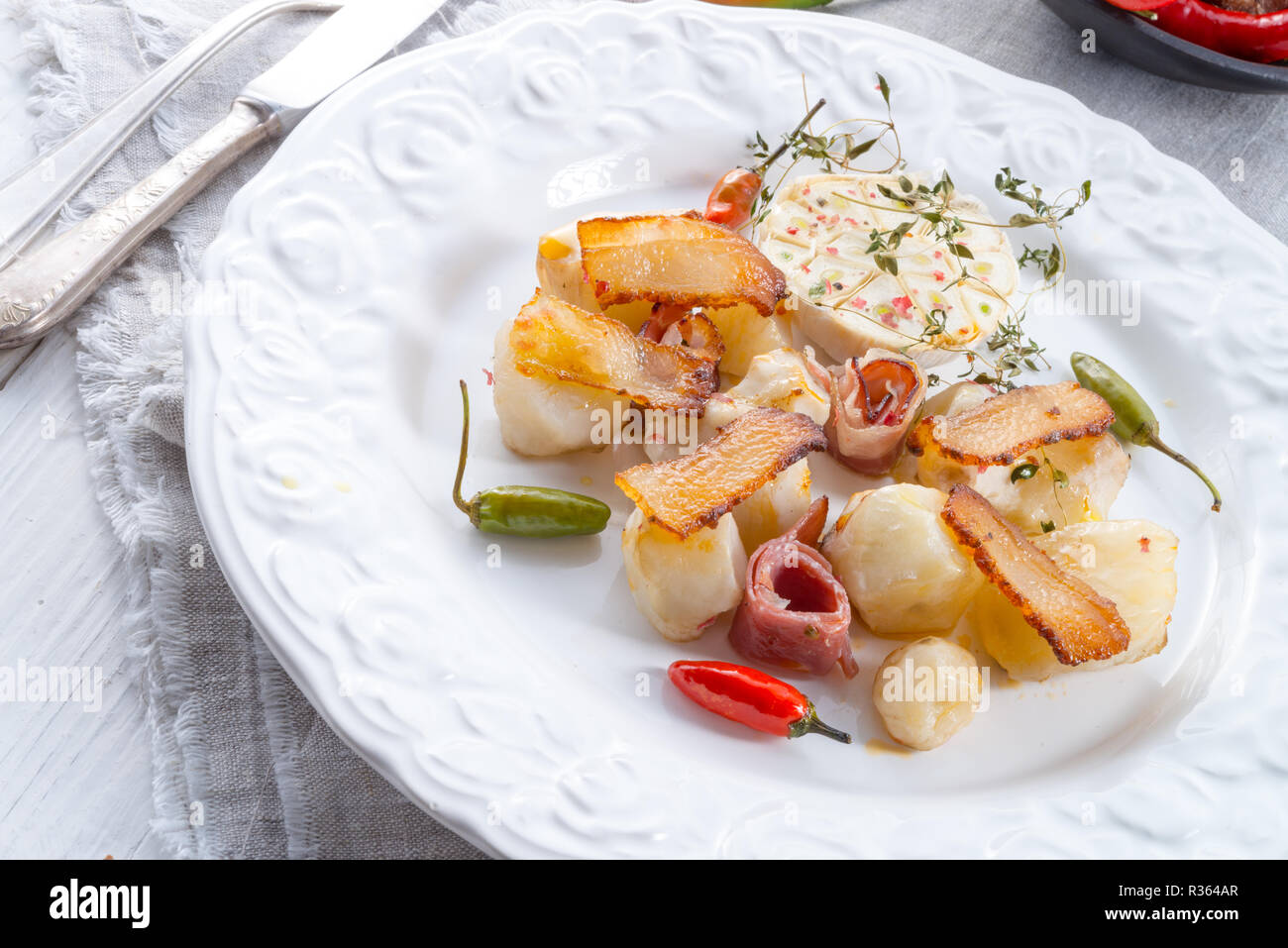 Topinambur gratiniert mit Schinken und Chili Stockfoto