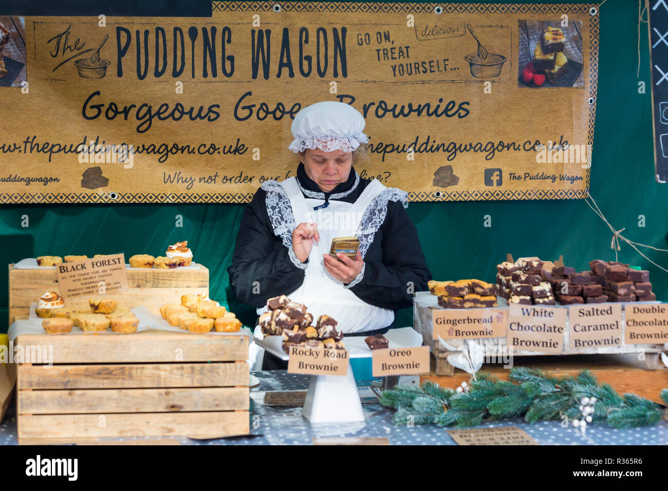 Der Pudding Wagon Brownies Marktstand Inhaber in Gloucester Quays Victorian Christmas Market, Gloucester, Gloucestershire im November Stockfoto