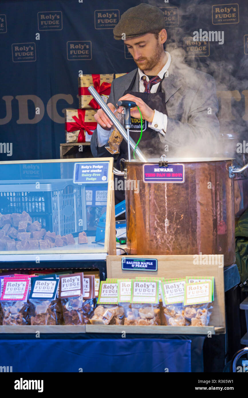 Roly's Fudge Market Stallhalter macht Fudge auf Gloucester Quays Victorian Christmas Market, Gloucester, Gloucestershire im November Stockfoto