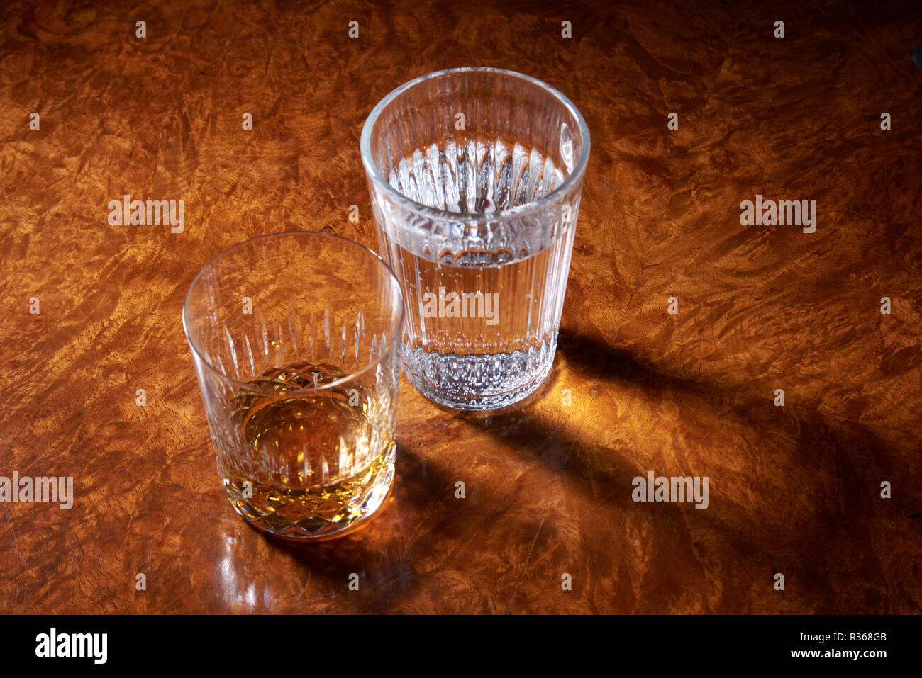 Trommeln des Whisky und Wasser auf einem entgratet Nussbaum Tisch. Landschaft noch leben. Stockfoto