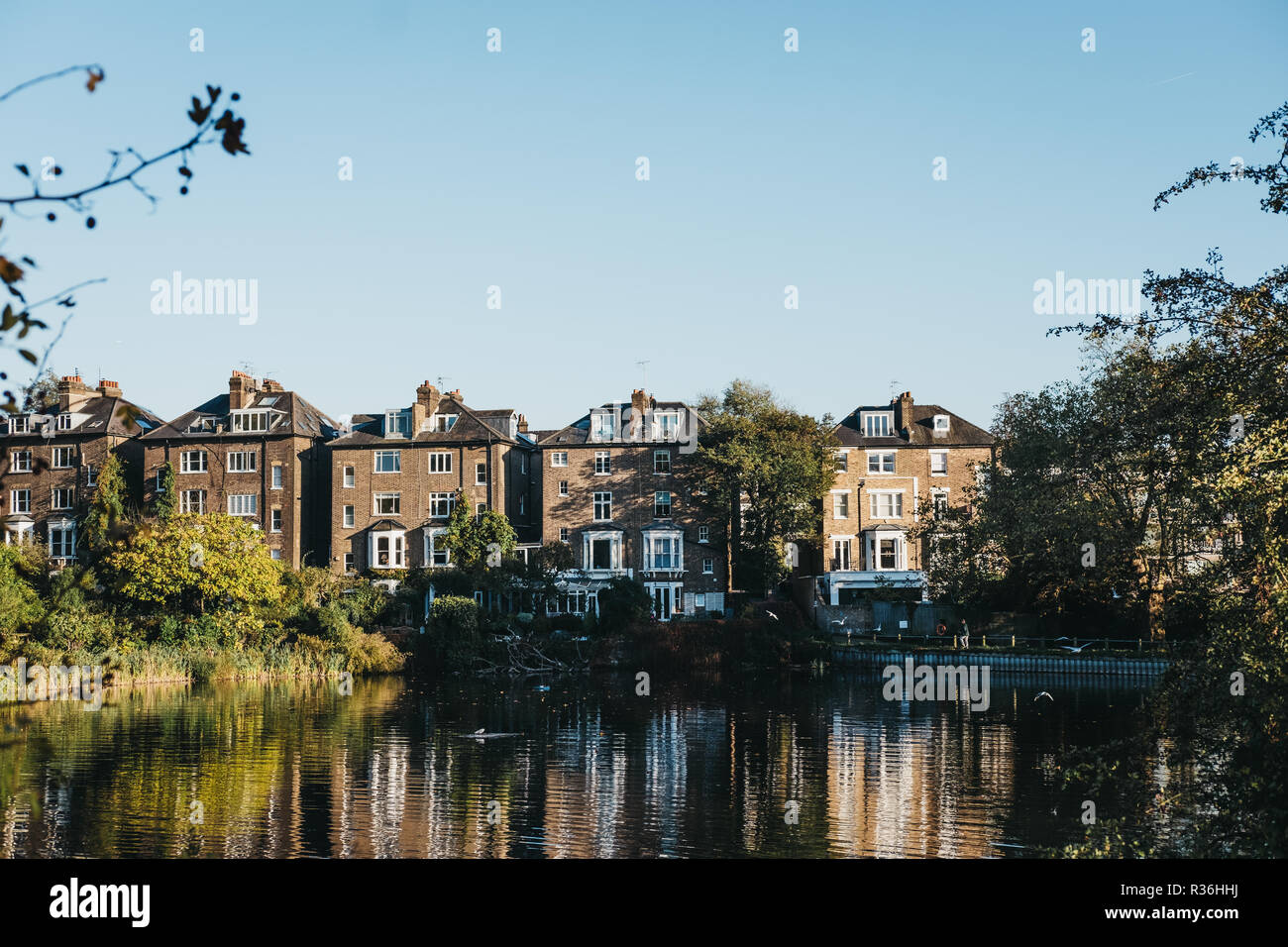 London, UK, 27. Oktober 2018: die Reihe der Halb-freistehende Häuser in Hampstead, mit Blick auf einen Teich in Hampstead Heath. Hampstead Heath umfasst 320 Hektar eines der Stockfoto