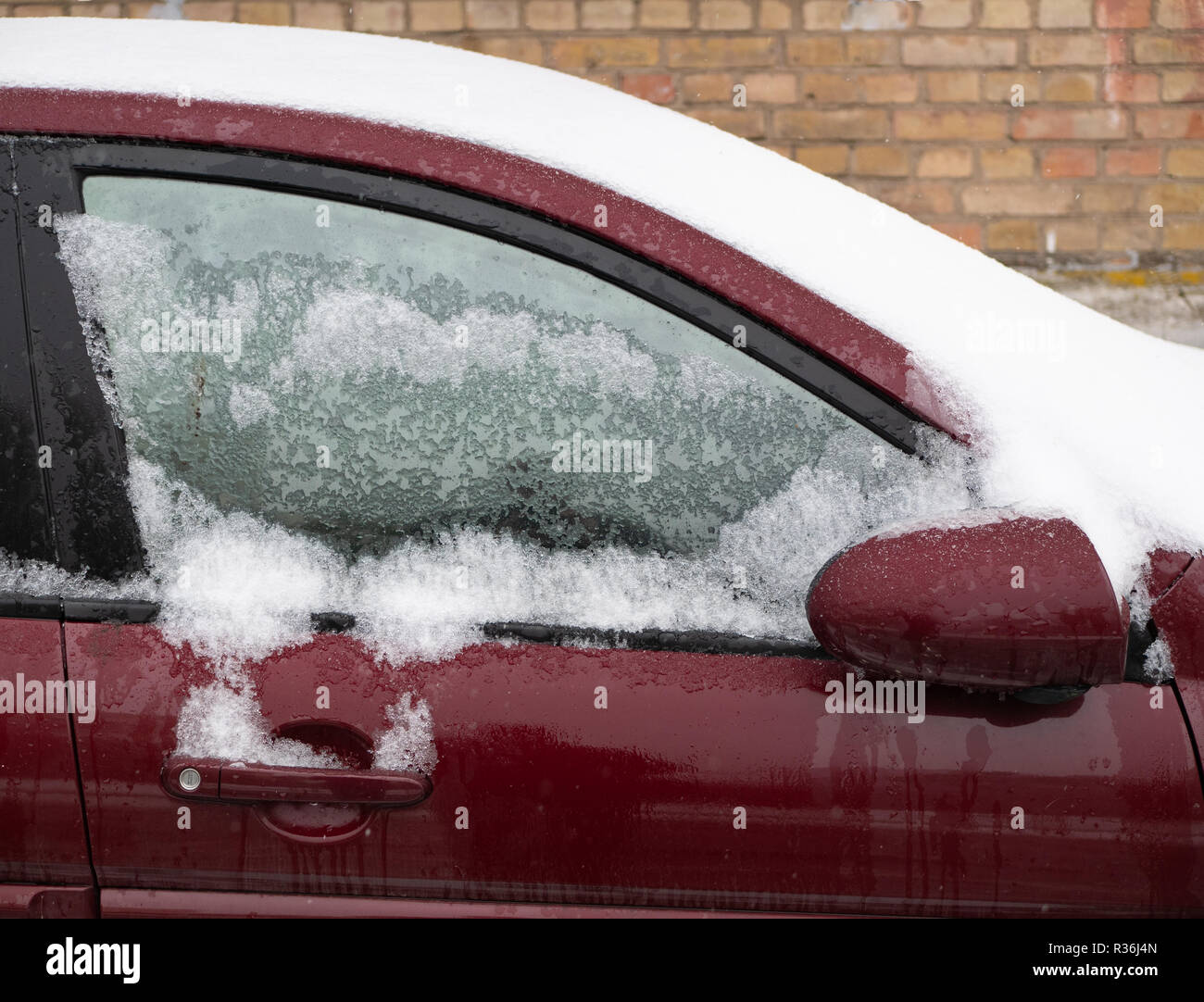 Gefrorene Seitenfenster von Burgund rot Auto. Schneedecke Frontscheibe und  Dach. closeup draußen Winter geschossen. Anti icing Flüssigkeit hilft  Stockfotografie - Alamy