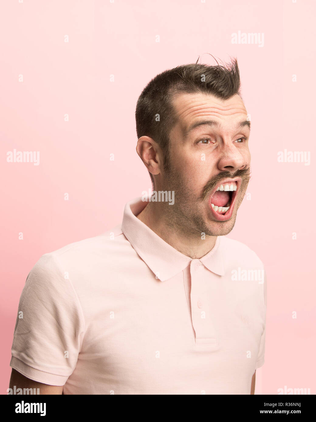 Das überrascht und erstaunt junge Mann schreiend mit offenen Mund auf rosa Hintergrund isoliert. Konzept der Schock Gesicht emotion Stockfoto