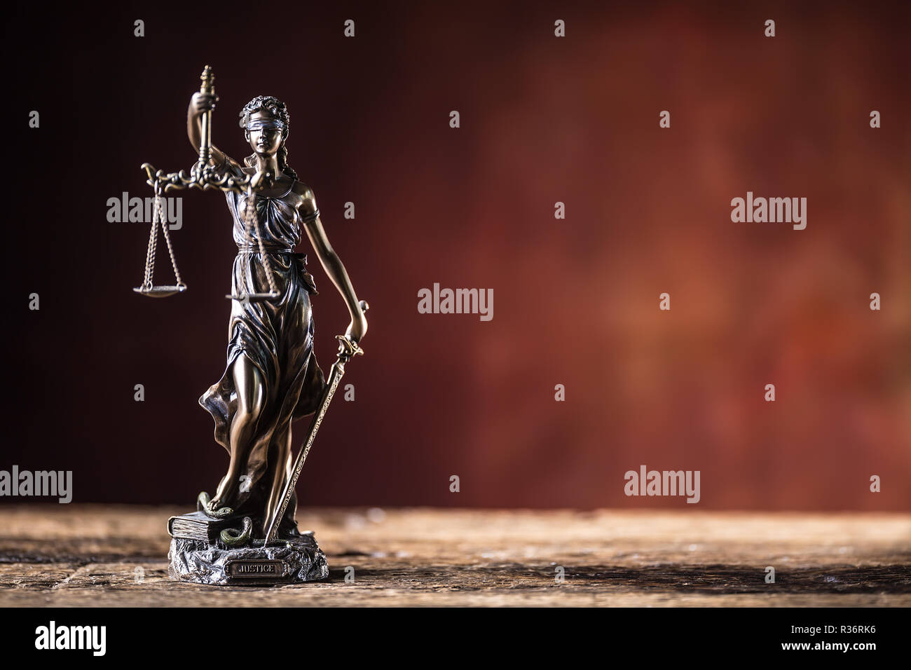 Lady "Justicia mit Schwert und Waage Bronze Figur auf hölzernen Tisch. Stockfoto