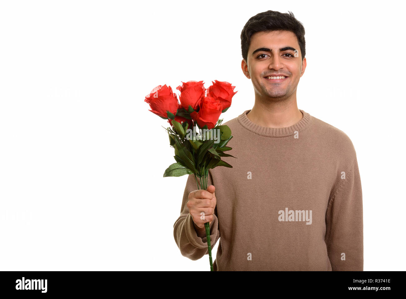 Junge glücklich Persischen Mann mit roten Rosen zum Valentinstag bereit Stockfoto