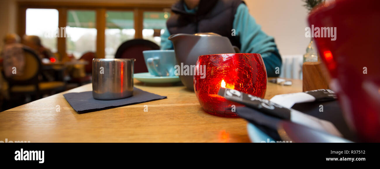Panorama, Nahaufnahme von modischem, farbigem Geschirr auf dem Tisch in der trendigen britischen Bistro-Bar. Tee für zwei Personen wird in modernem Ambiente serviert. Stockfoto