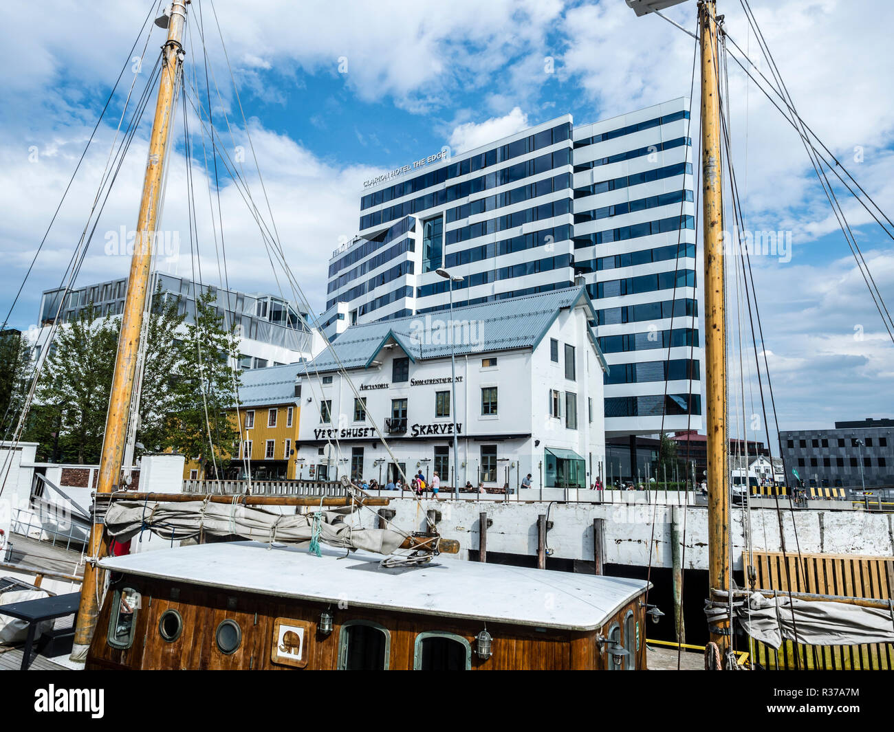 Tromsö Stadtzentrum, am Hafen, Hotel Clarion "die Kante", Pie-förmigen Gebäude, das im traditionellen Restaurant karven', alte hölzerne Segelboot, Tromsö, Stockfoto