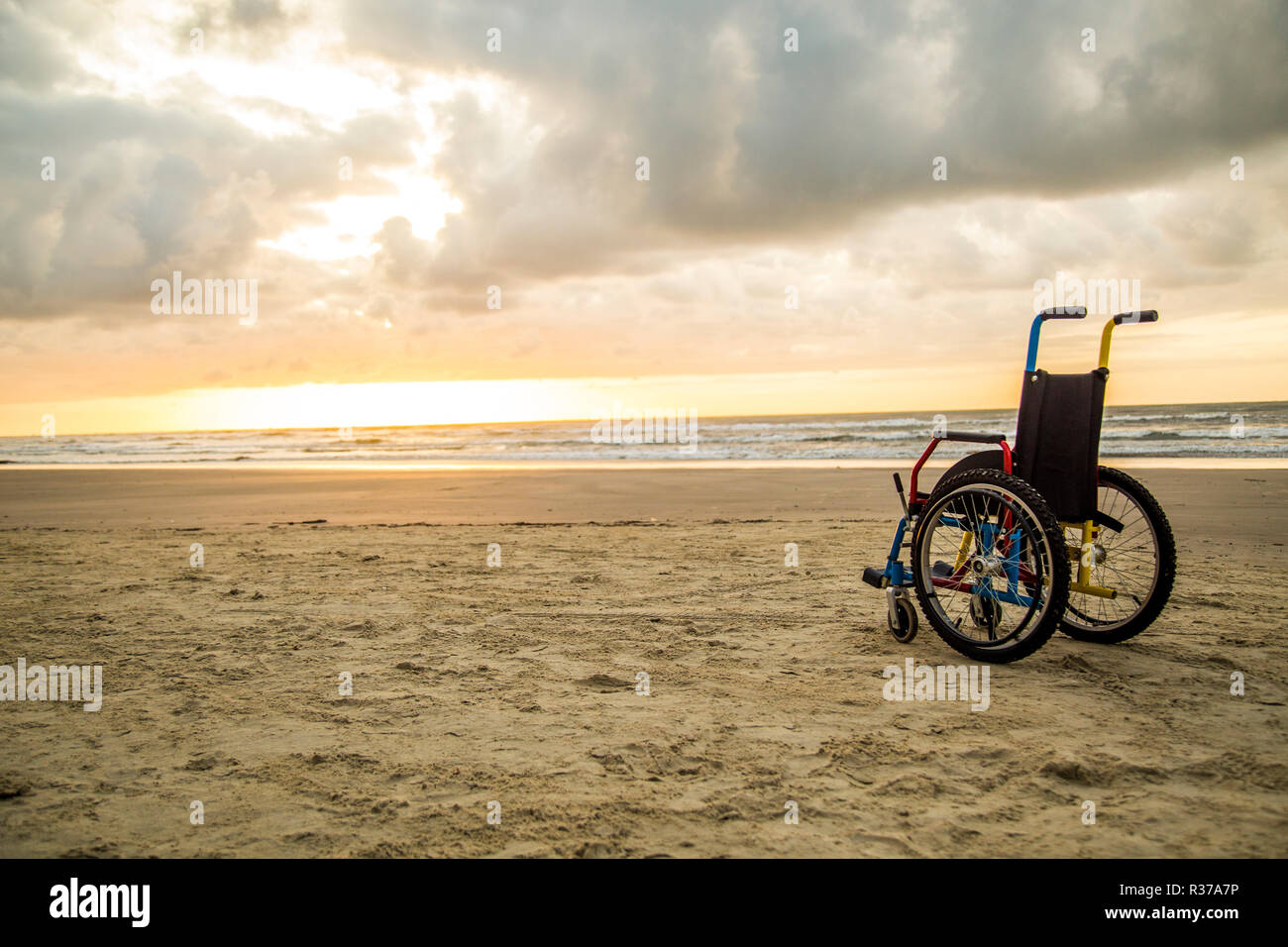 Sonnenuntergang kindliche Rollstuhl Horizont sand Stockfoto